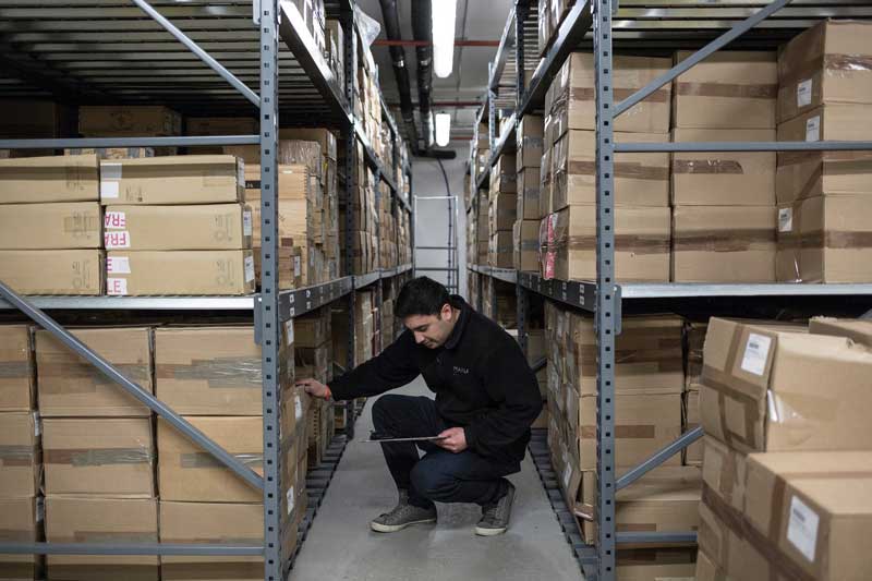 man taking inventory in wine storage facility